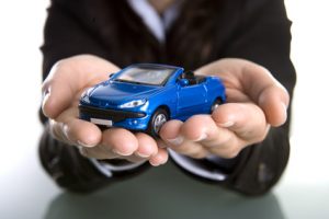 businesswoman holding car in the hands - insurance or car busine