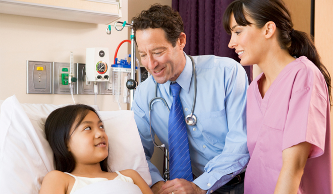 Doctor And Nurse Talking To Young Girl